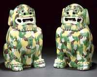 early 19th century A pair of egg and spinach glazed models of Buddhistic lions